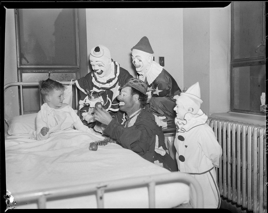 Circus clowns visit sick boy. CC photo Boston Public Library.